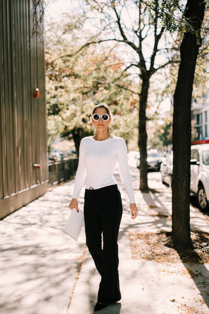 Navy athleisure pants with fitted white top and black slingback pumps