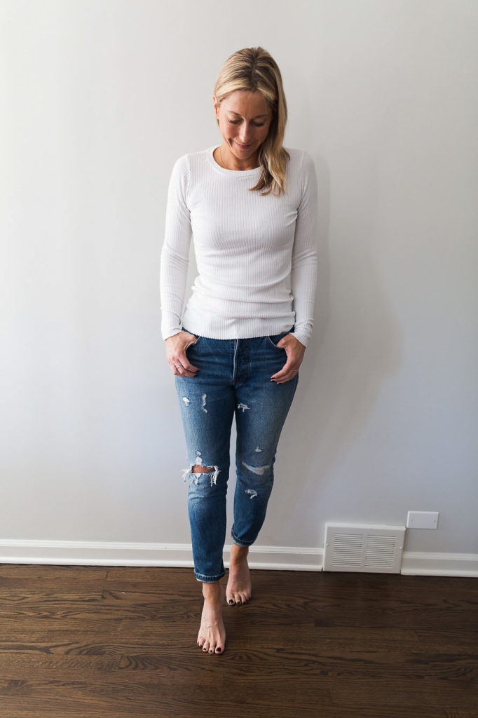 woman wearing Denim and a long sleeve white ribbed top 
