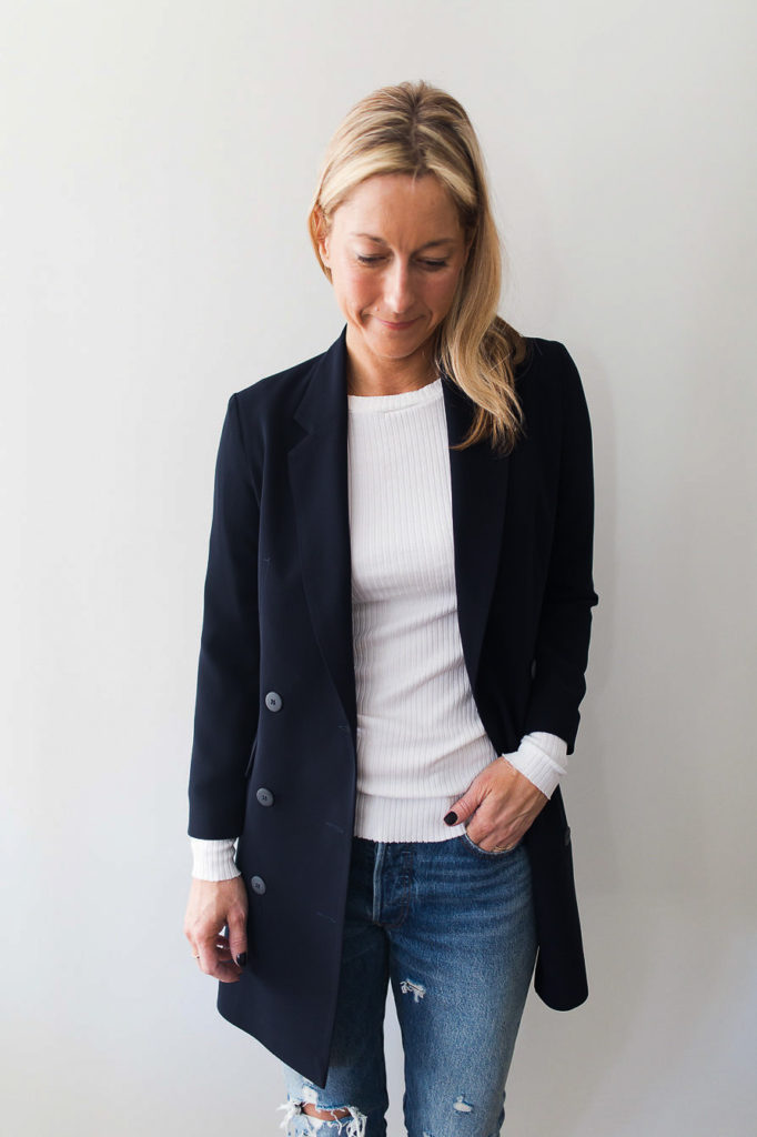 woman wearing a A longer styled navy blazer also serves nicely as a lightweight coat 