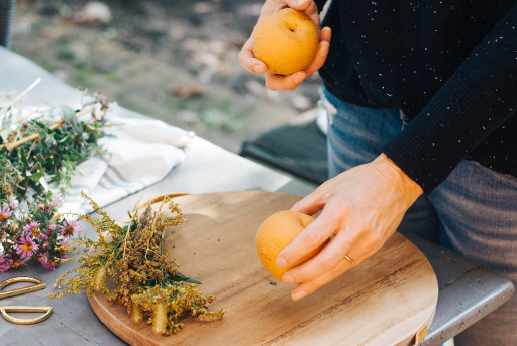 Once your flowers are arranged, add some seasonal fruit to your display. Pears, pomegranates and apples are all great options for this time of year.