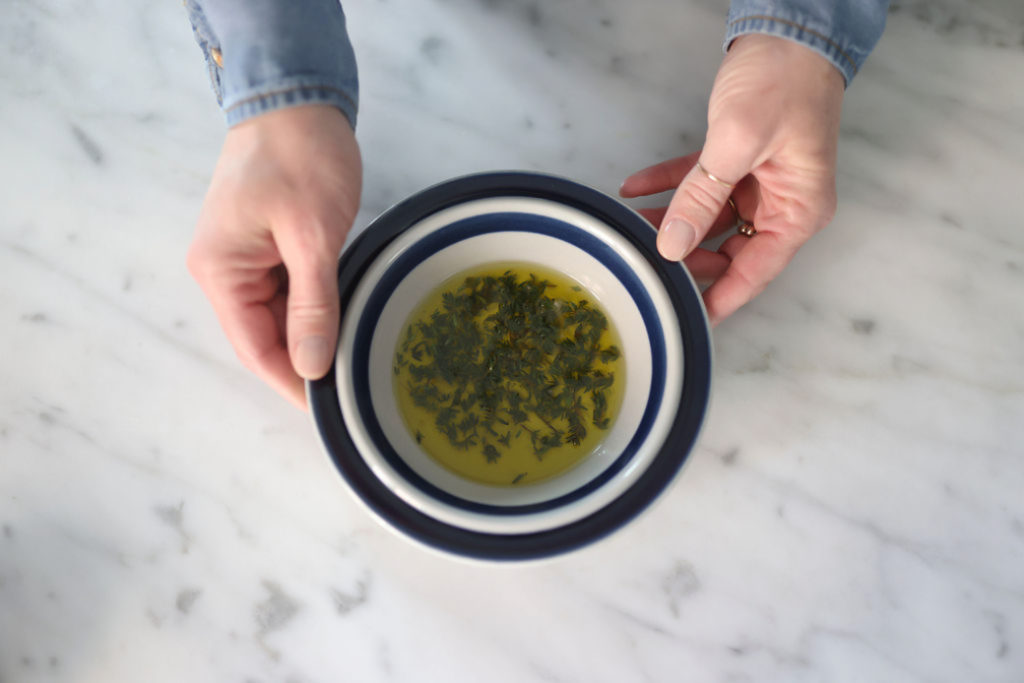 top view of oil marinated herbs in a small bowl